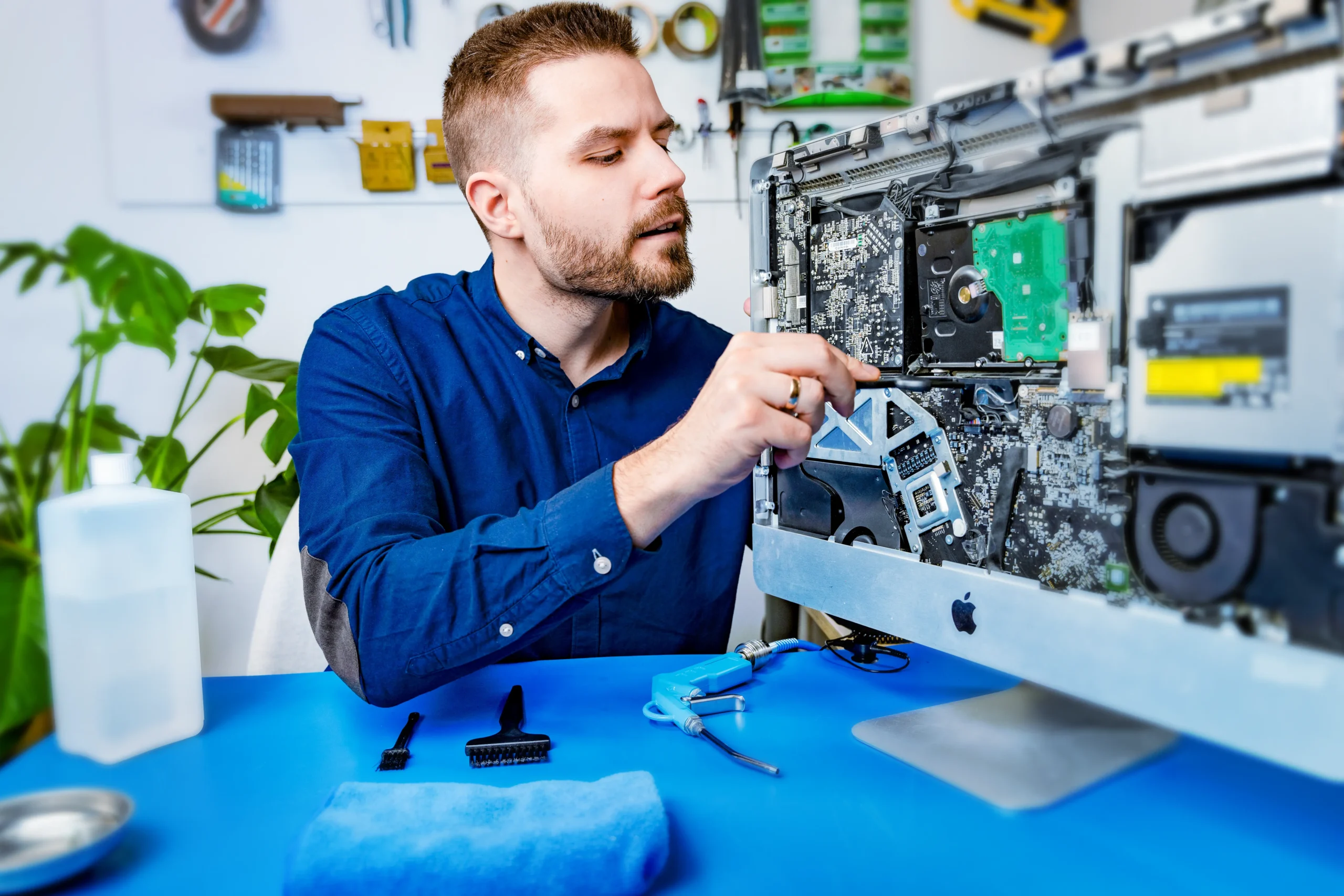 concentrated IT-Dokter expert performs a computer cleaning and cleaning utensils are lying around